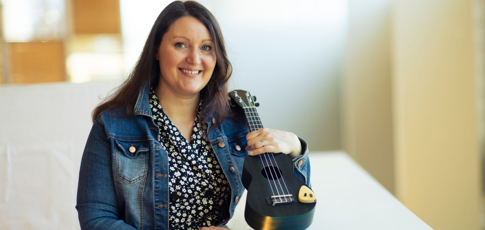 Nainen ukulele käsissään.