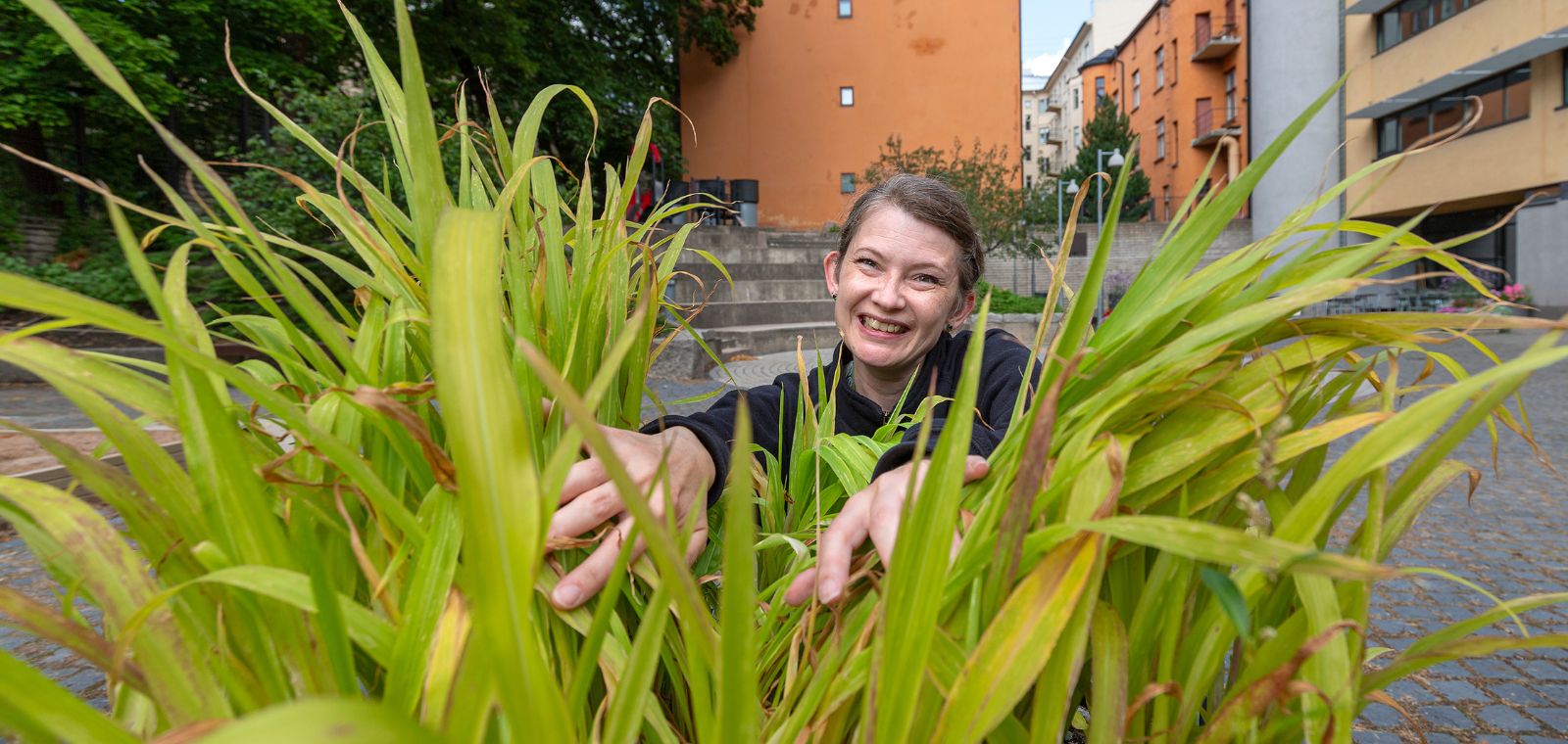 Nainen kerrostalojen sisäpihalla.
