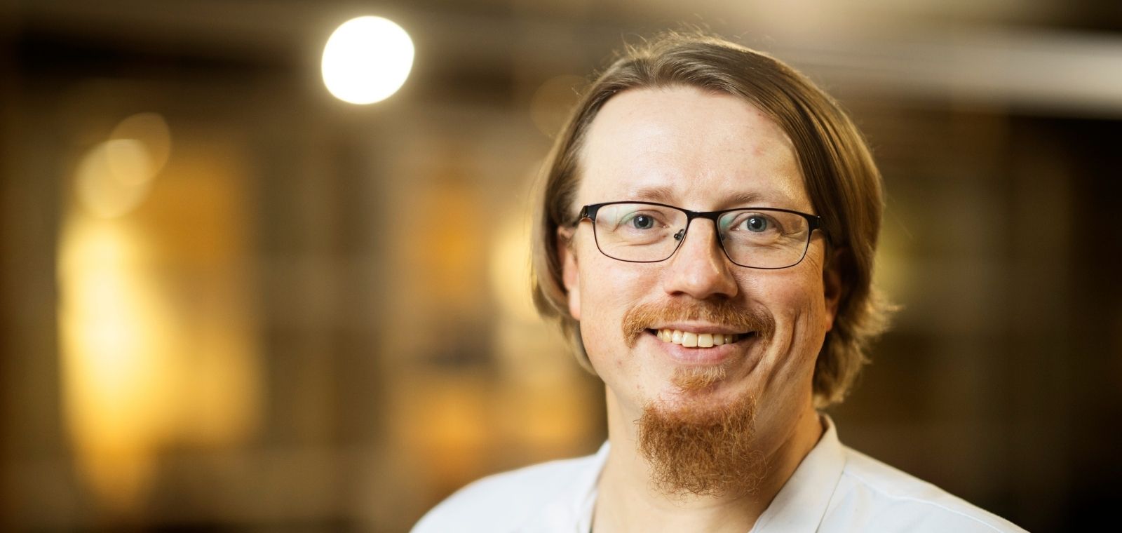 Parrakas mies lääkärin takissa.