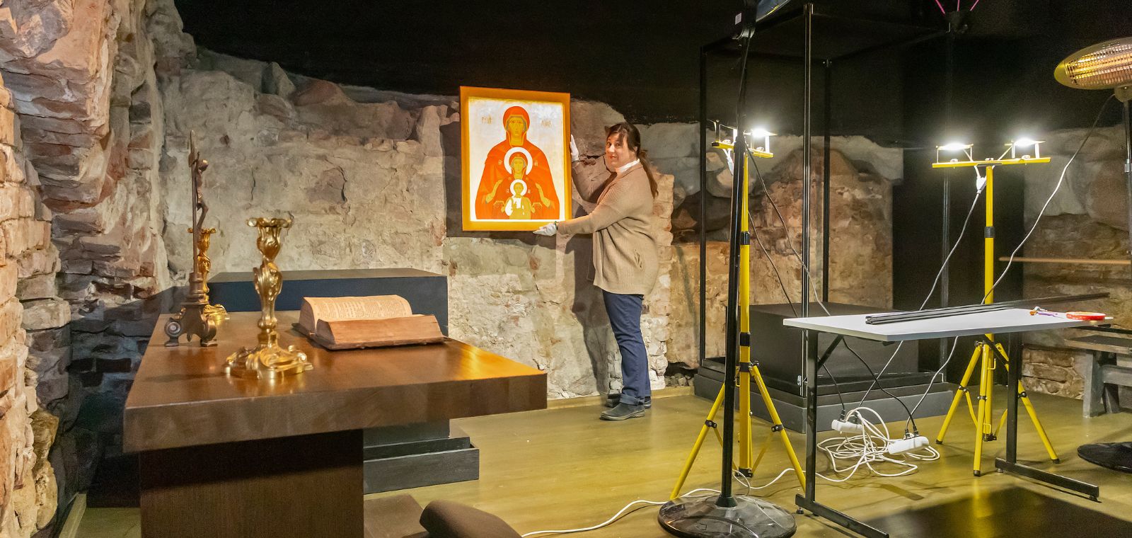 Nainen rakentaa näyttelyä museotilaan.