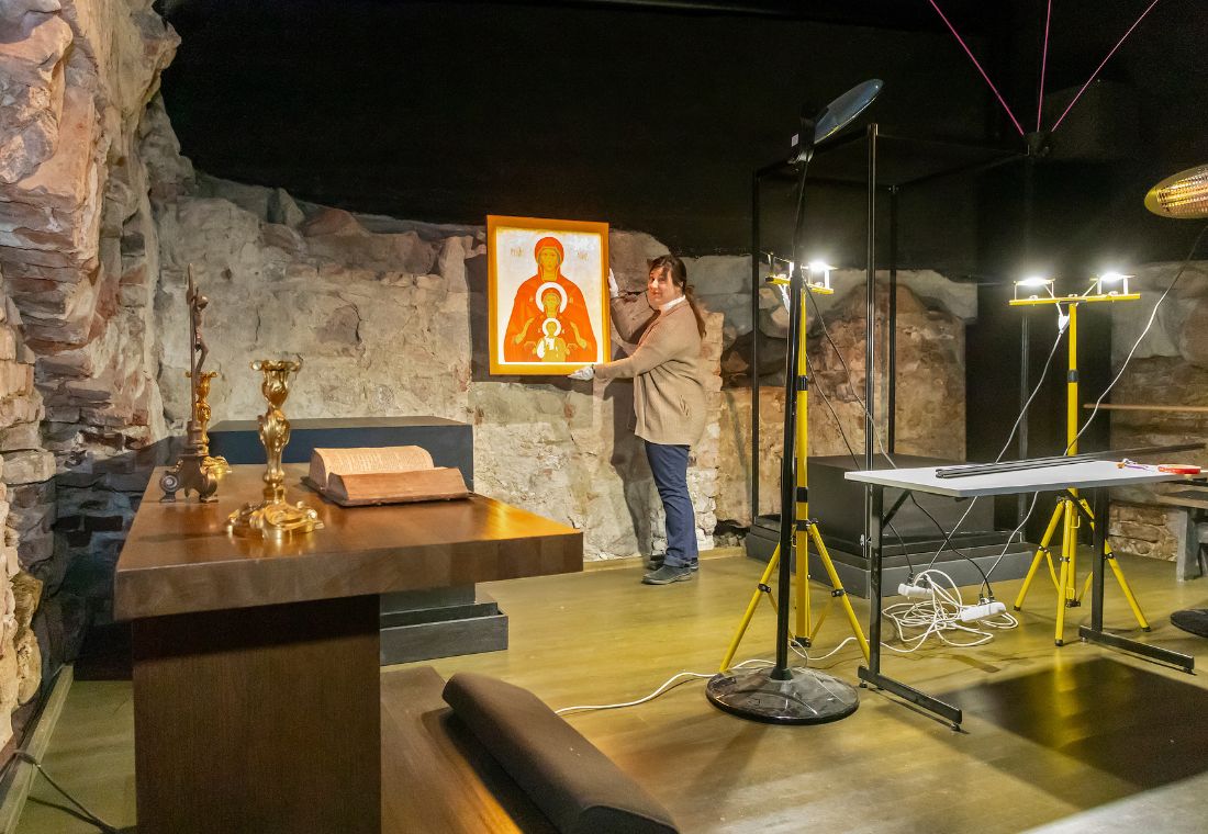 Nainen rakentaa näyttelyä museotilaan.