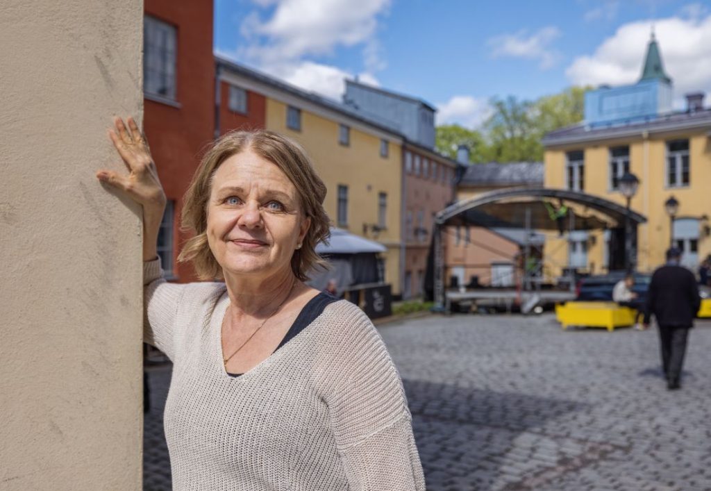 anu åberg taiteen talon sisäpihalla. Taustalla lava ja kattojen yllä pilkistää Tuomiokirkon torni.