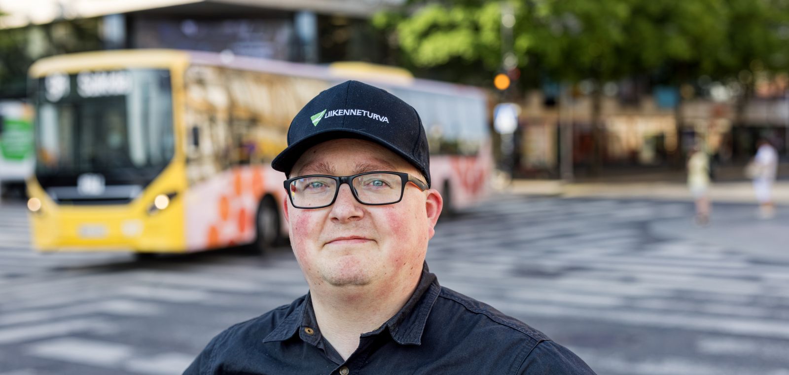 Lippalakkipäinen mies risteyksessä.