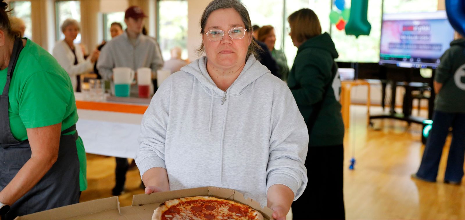 Nainen pitelee pizzalaatikkoa